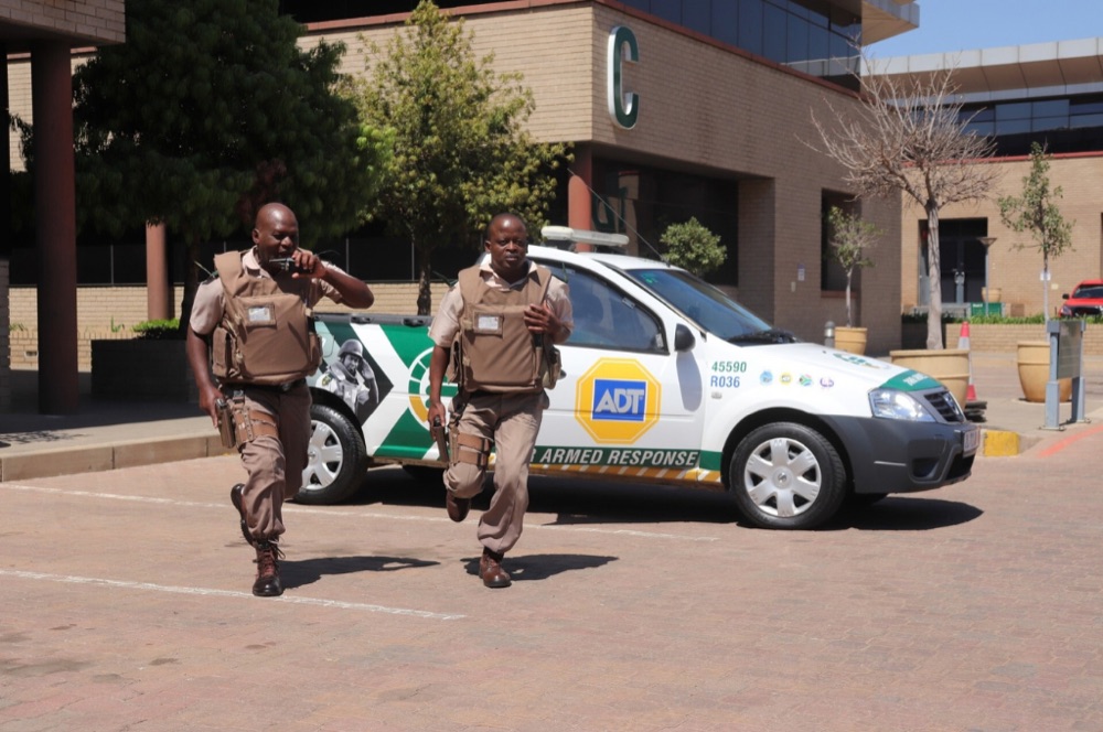 Fidelity ADT armed response officers running to a branded response vehicle