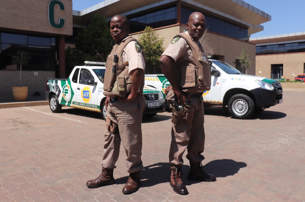 Fidelity ADT armed response officers standing beside marked response vehicles